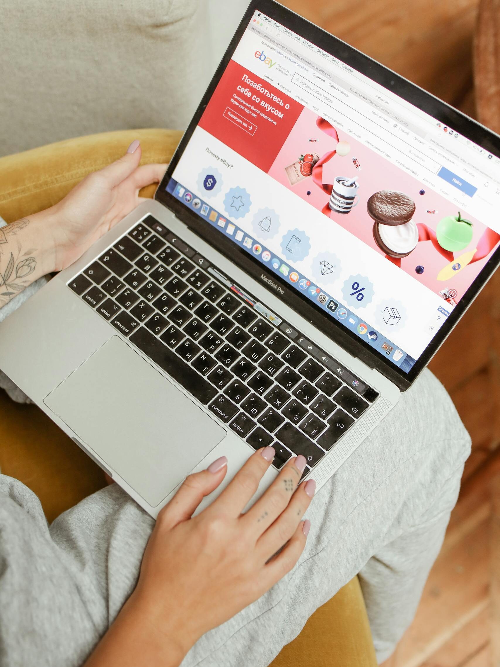 A woman sits comfortably indoors, browsing an online shopping website on her laptop.